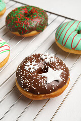 Grid with tasty Christmas donuts on white background, closeup