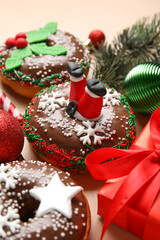 Tasty Christmas donuts on beige background, closeup