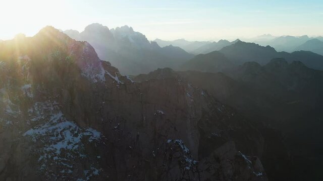 Cinematic drone shot of the Mangart mountain in the Julian Alps in Slovenia, into the sun