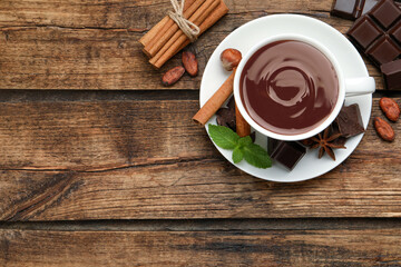 Flat lay composition with yummy hot chocolate on wooden table, space for text