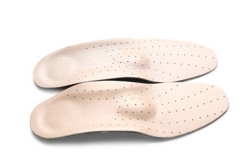 Beige orthopedic insoles on white background