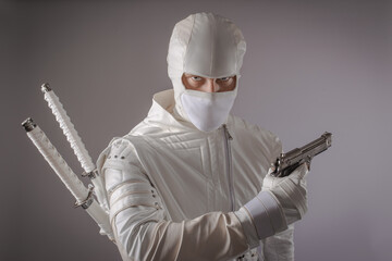 man in white ninja clothes in the studio on a black background © AleksFil