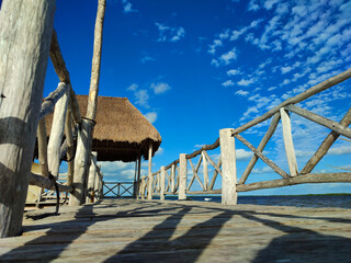 Palapa y puente de madera en el mar caribe de vacaciones en el paraiso de la playa