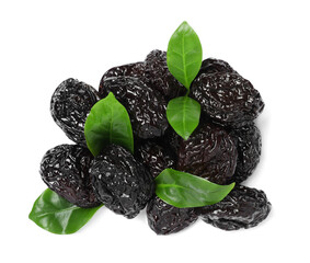 Heap of sweet dried prunes and green leaves on white background, top view