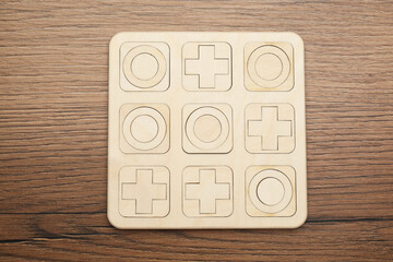 Tic tac toe set on wooden table, top view