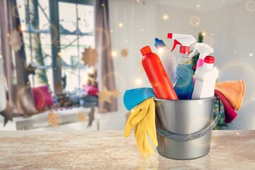 Cleaning before Christmas. Multicolored cleaning supplies. Sponges, rags and spray with festive decorations against modern home background