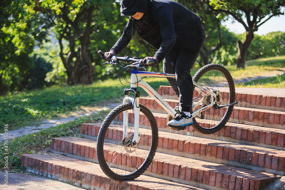 Wall mural woman free rider riding bike going down city stairs