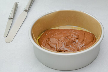 Cake pan with cake batter close up on kitchen table, close up baking process.
