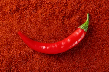 Poster Fresh chili pepper on paprika powder, top view © New Africa