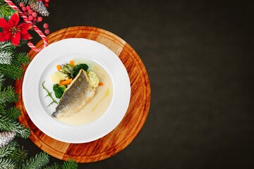 Tasty fish for preparation for the holiday Christmas with Christmas trees and Christmas decorations.