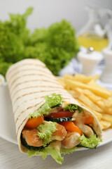 Delicious shawarma with chicken meat and fresh vegetables served on white wooden table, closeup