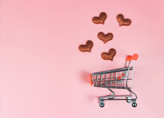  flat lay of  red glitter hearts and  shopping cart on pink background. Valentine's shopping...