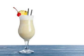 Tasty Pina Colada cocktail on blue wooden table against white background, space for text