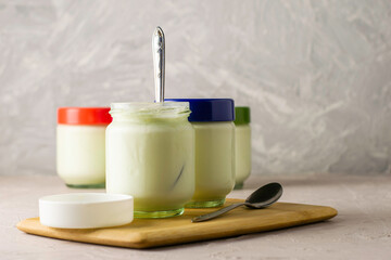 Fototapeta na wymiar cans of homemade yogurt and spoons on a cutting board