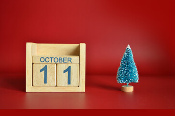 October 11, Calendar design with Christmas tree on red table background.