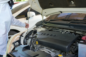 Vehicle safety concept, Woman's hand checking car engine before driving.
