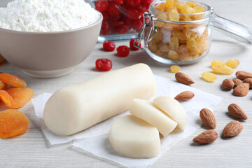 Marzipan and other ingredients for homemade Stollen on white wooden table. Baking traditional German Christmas bread