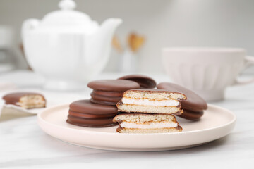 Plate with delicious choco pies on white marble table in kitchen