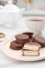 Plate with delicious choco pies on white marble table in kitchen