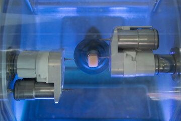 Dental milling machine carving out shape of human teeth close-up. Modern medical technologies in...