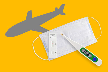 Face masks, thermometer and AG test isolated on a yellow background. Covid 19 alpha, beta, gamma,...