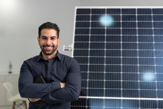 Solar energy seller posing near to panel in office, smiling 