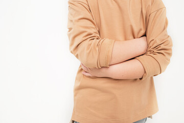 Close-up of the baby's abdomen. The child is holding on to his stomach. A boy in a beige...