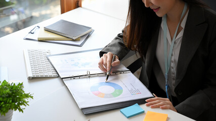 Businesswoman checking financial graphs and diagrams on paperwork