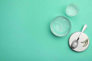 Flat lay composition with cosmetic gel and aloe on turquoise background, space for text