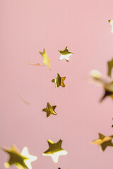 Background with flying gold confetti stars. Pink background. Wallpaper. 