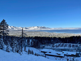 Lake Tahoe and the base of a ski resort from the slopes on a bluebird winter day