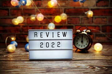 Review 2022 text in light box with alarm clock and LED cotton balls decoration