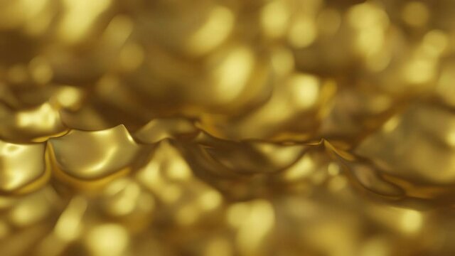 Gold liquid waves in slow motion with a narrow depth of field. Celebration gold bokeh animation background.
