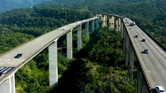Aerial landscape of landmark highway road at green forest trees and mountains. Traffic at famous road way to brazilian south coast. Legendary engineering construction. Brazilian road landmark.