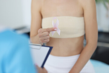 Female client hold white ribbon sign of breast cancer