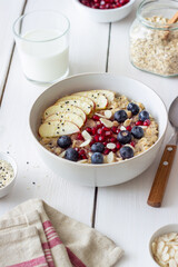 Oatmeal porridge with apple, pomegranate, blueberries and almonds. Healthy eating. Vegetarian food. Breakfast.