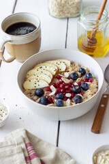 Oatmeal porridge with apple, pomegranate, blueberries and almonds. Healthy eating. Vegetarian food. Breakfast.