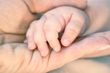 Obraz na płótnie Canvas Mother holds newborn baby hand. Care concept. Toned photo