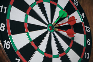 Concept of competition and goal achievement.Achieving goals in business and life.Dartboard with three darts stuck right center of target.