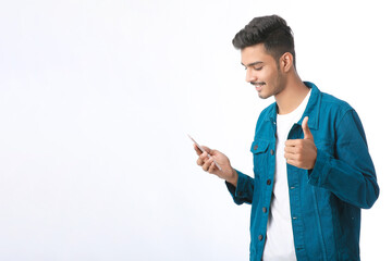 Young indian man using smartphone and giving expression on white background.