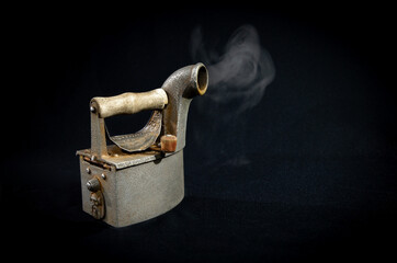 Ironing iron on black background, vintage