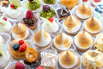 Assorted different mini cakes with cream, chocolate and berries- Sweets offered at the pastry shop