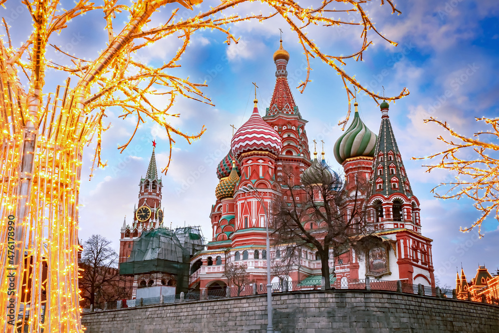 Wall mural Moscow Christmas. Russia New Year. St. Basil's Cathedral on Christmas morning. Kremlin tower on blue sky background. Winter holidays in capital of Russia. Garlands on Red Square. Russian Federation