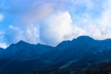 Beautiful mountain landscape. Mountains and evening sky with cumulus clouds. Nature background 