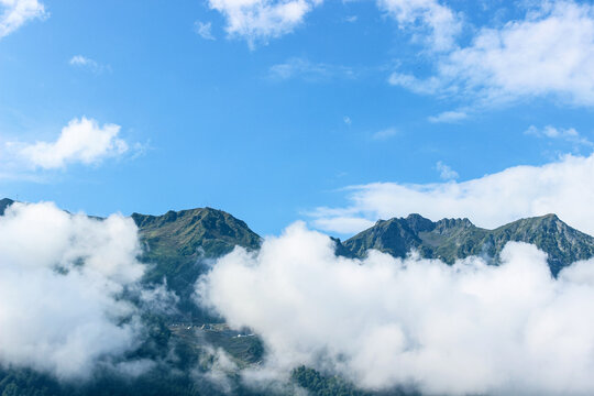Thick white clouds float in the mountains. Beautiful mountain landscape. Nature background 