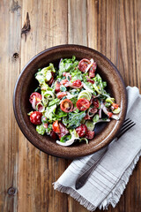Simple Salad with Cherry Tomatoes, Lettuce, Red Pepper, Leek and Onion. Dark wooden background. Top view. 