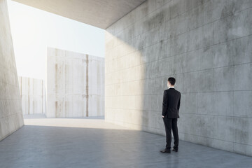 Man standing in abstract concrete tile space interior background with sunlght. Design and abstraction concept.