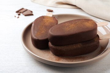 Delicious glazed ice cream bars on white wooden table, closeup