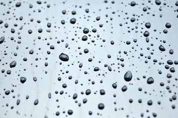 The deep water droplets on the black surface and some of the water droplets are blurry