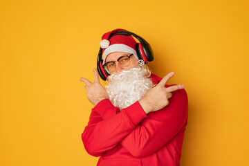 DJ Santa Claus in headphones. Christmas songs and music. yellow background.